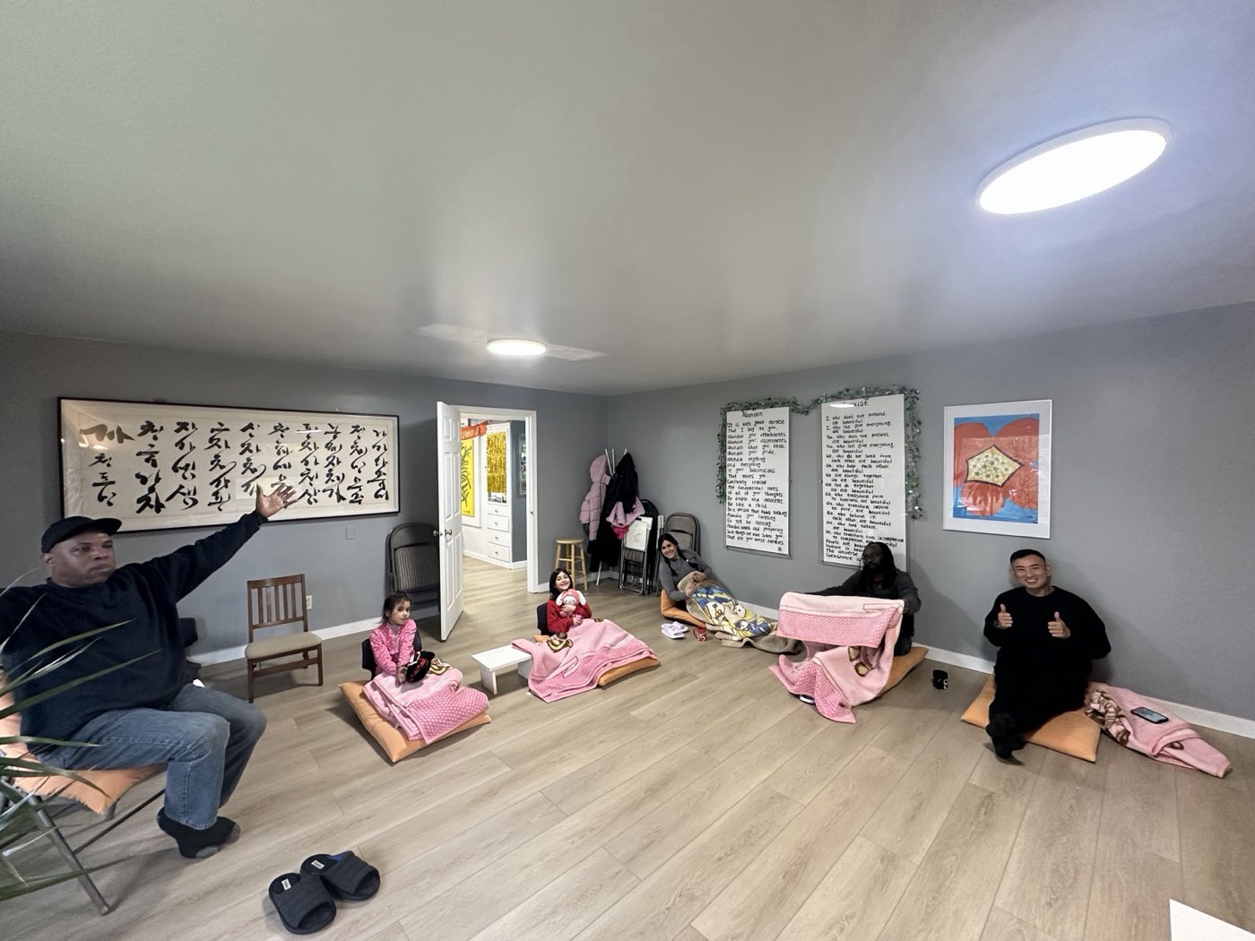 Members of all ages sitting on cushions in the meditation room